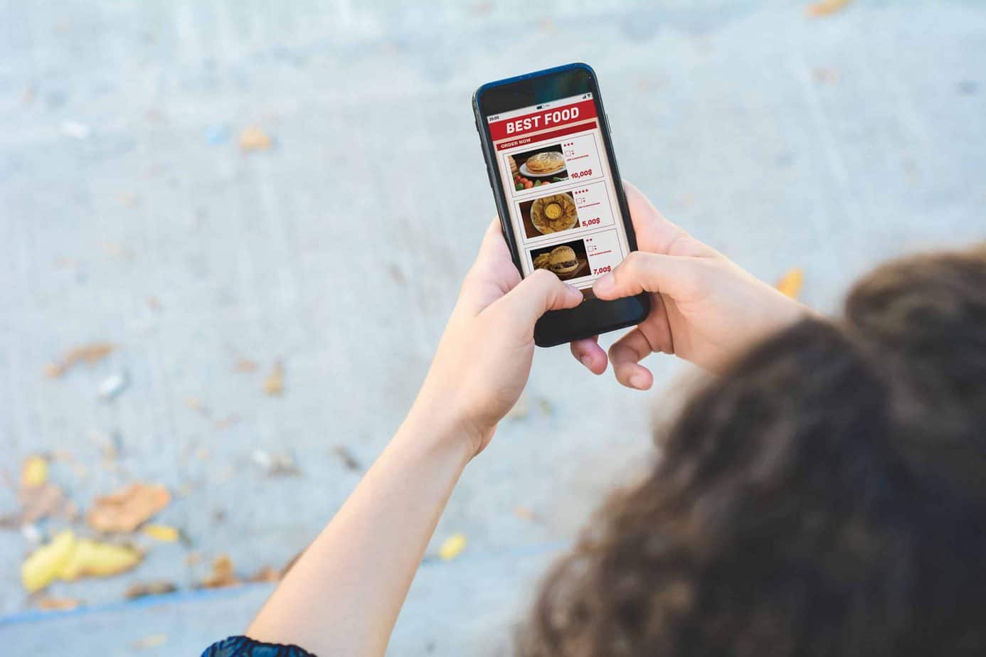 Close up woman with smartphone ordering take away food online. Delivery concept. All screen graphics are made up by us
